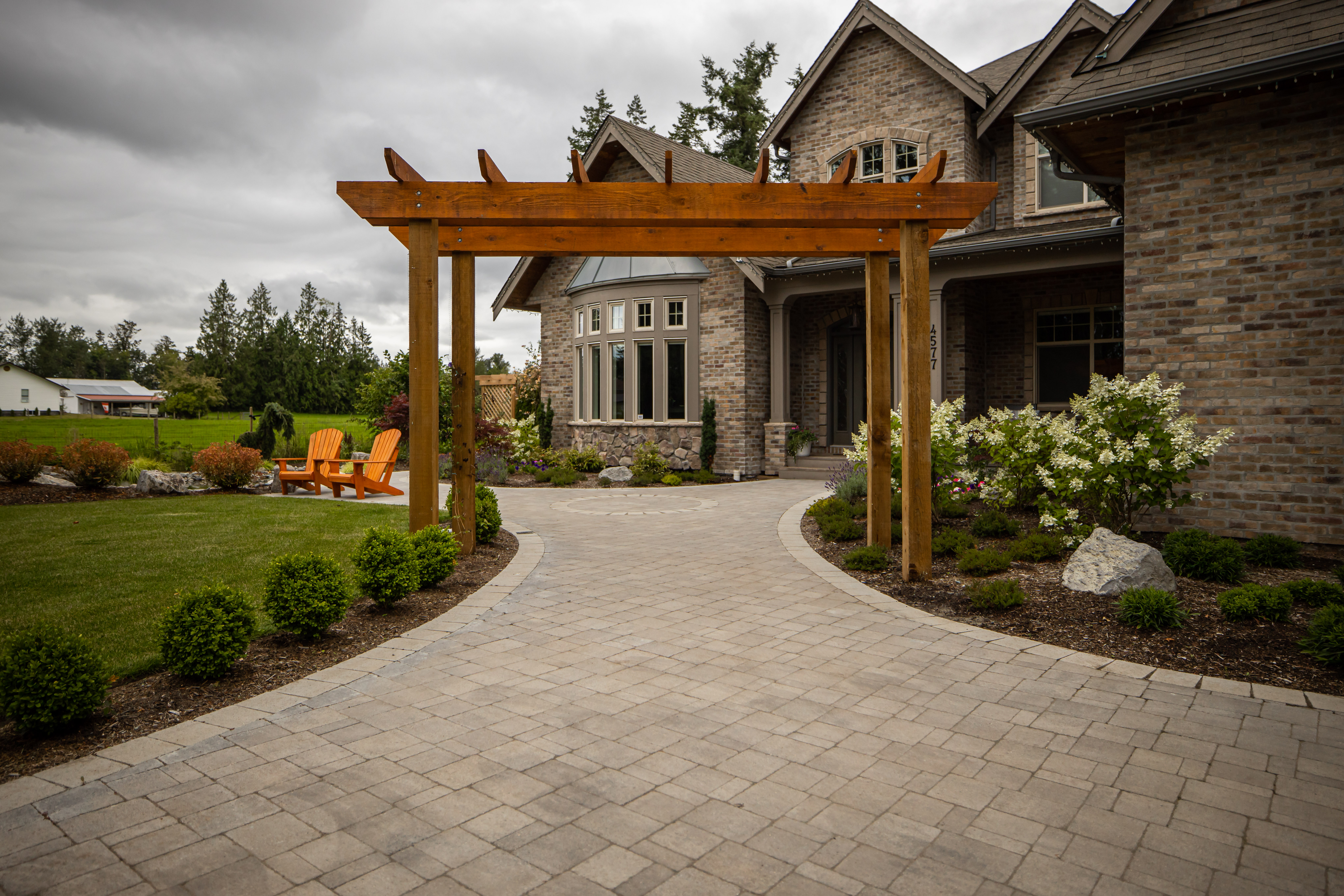 large brick house with wood arbour